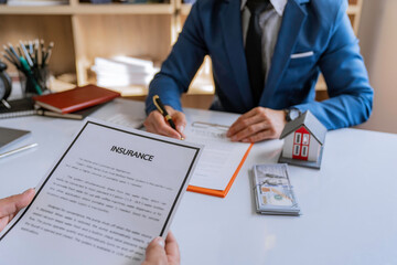Real estate broker agent presenting and consult to customer to decision making sign insurance form agreement, home model, concerning mortgage loan offer for and house insurance.