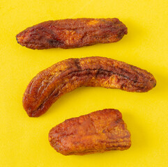 Dried bananas on a yellow background.
