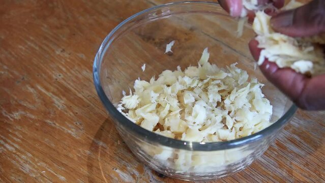 Man of African ethnicity flaking soaked saltfish in preparation for ackee and saltfish, the national dish of Jamaica