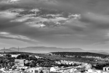 Traditional Spanish whitewashed village with mountain and ruined castle on the sumit. Monochrome black and white