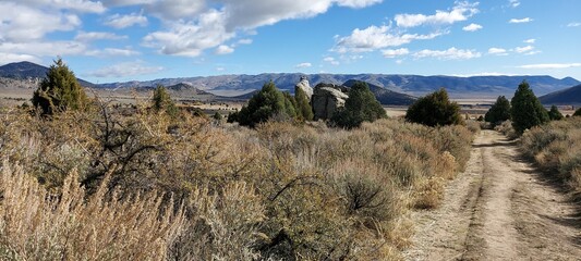 A country road leading across the plain to the mountains against the backdrop of the autumn sky.