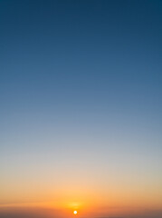 Dusk sky vertical with colorful orange sunlight and dark blue in the evening on twilight 