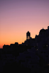 Fototapeta premium Amazing golden sunset and silhouette view of churches and the village of Imerovigli in Santorini