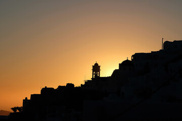 Obraz premium Amazing golden sunset and silhouette view of churches and the village of Imerovigli in Santorini
