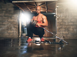 Fototapeta premium Adding more weight to his workout. Full length shot of a muscular young man adding weights to his bar.