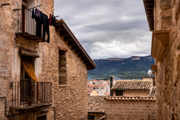 Traditional houses made of stone in a rural village, mountain ranges Els Ports at the background, Valderrobres, Teruel, Aragon, Spain