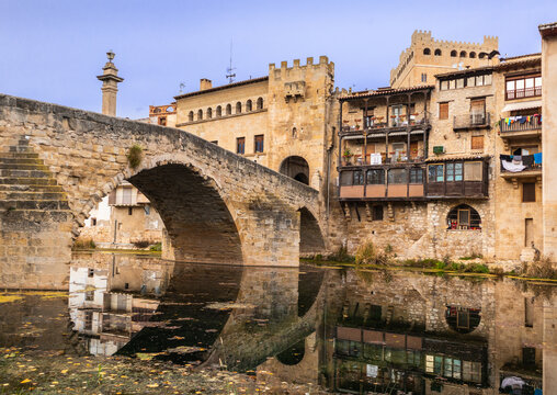 Roman bridge made of stone over the Matarra&ntilde;a river, medieval entrance tower to the beautiful town of Valderrobles, Teruel, Aragon, Spain