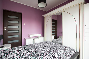 Pokój sypialny z łóżkiem i szafą w stylu retro