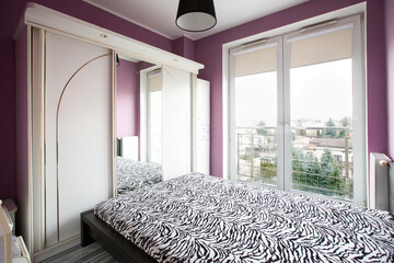 Sypialnia ze stylową szafą i dużymi oknami