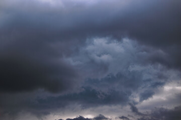 gray clouds floating at low altitude, enveloping swirling storm clouds.