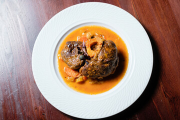 Meat baked with vegetables and yellow sauce top view.