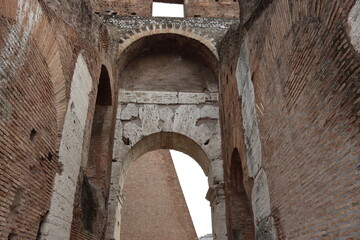 Fototapeta na wymiar ROME, ITALY - February 05, 2022: Panoramic view of inside part of Colosseum in city of Rome, Italy. Cold and gray sky in the background. Macro photography of the arches.
