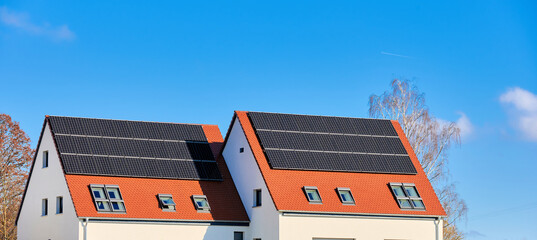 Doppelhaus mit Solardach vor blauem Himmel