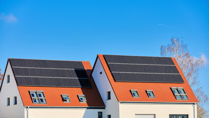 Doppelhaus mit Solardach vor blauem Himmel