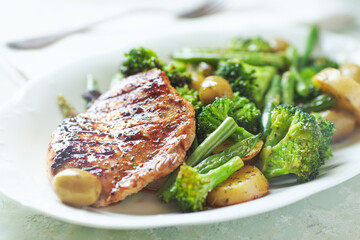Grilled Turkey Breast with oven baked potatoes and broccoli. Close up.	