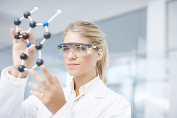 On the brink of a medical break-through. A gorgeous young scientist looking at a molecular...