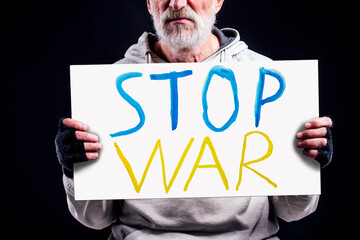 poor caucasian old men with cardboard text stop war in studio black background. Russian versus...