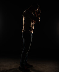 Silhouette of a guy posing in studio while standing
