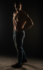 Fototapeta na wymiar Silhouette of topless guy posing and flexing in studio