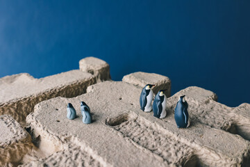 Fototapeta na wymiar Cute miniature toy penguin colony. Wild animal family.