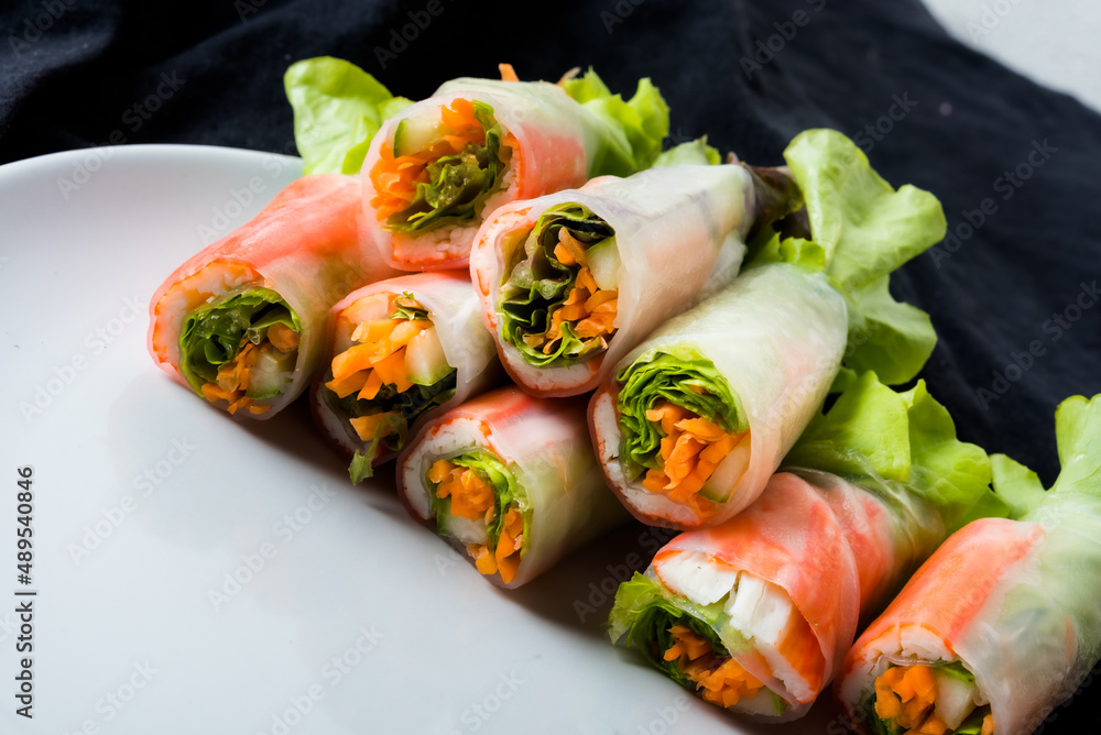 Wall mural fresh vegetable salad roll in noodle tube on dish isolated on white background asian street food