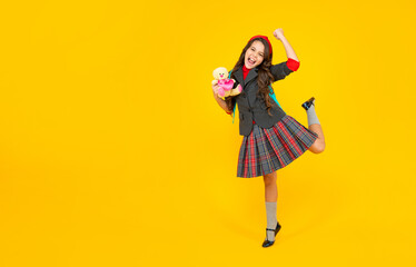 glad kid in school uniform with toy on yellow background, september