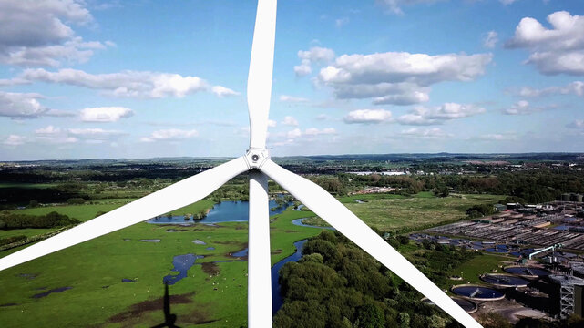 Wind turbine blades in aerial view, agricultural fields and industrial manufacturing background, clean and green Energy Production.