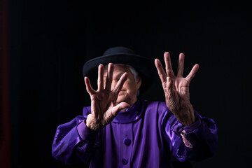 Palm of the hand of an old woman a black background.