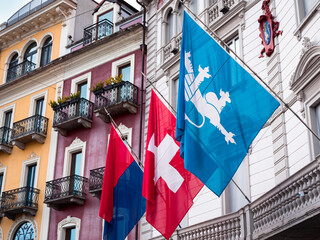 Locarno, Switzerland - December 29, 2021: Flags of Ticino, Switzerland and the city of Locarno in front of the city hall in Locarno