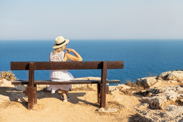 Lonely woman sitting on a bench and looks at the lagoon. Summer vacation holiday.
