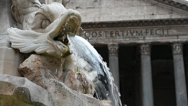 Antique travertine fountain with fish sculptures on piazza Rotonda outside temple of gods Pantheon