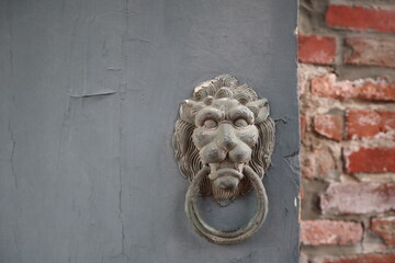old door knocker of lion on the blue door with retro red brick wall