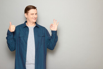 Portrait of happy mature man showing okay and thumb up gestures