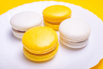 Sweet and bright banana and currant macarons on a white plate. French dessert.