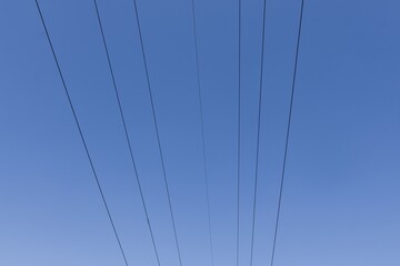 High voltage columns, in the background with blue sky and clouds. Prices of electricity, consumption, ecology.