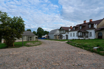 View of the main street of Izborsk Pechorskaya Street with old traditional merchant estates and a paved road on a summer morning, Izborsk, Pskov region, Russia
