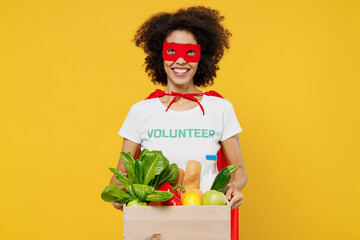 Young woman of African American ethnicity in white volunteer t-shirt super hero costume hold food...