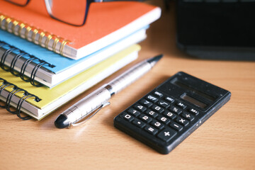 Close up of blue calculator and notepad on color background 