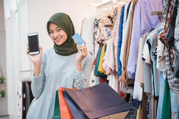muslim hijab woman holding smart phone and credit card