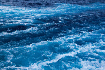 Fototapeta premium Ocean close up. Background of blue water with white foam.