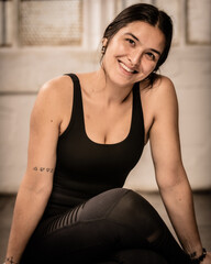 Young Los Angeles yoga teacher sits in an industrial setting after a session of practice.