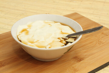 Wedang Tahu or Kembang Tahu, traditional dessert made of soybean pudding with palm sugar and ginger syrup