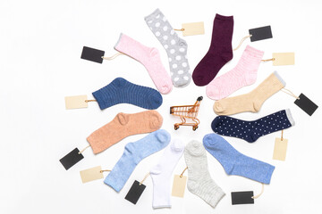 Various modern trendy women's cotton socks set with shopping cart and price tags on white background. Fashionable socks store. Socks shopping, sale, merchandise, advertisement concept