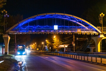 Public transport on the background of the bridge at night. Night highway.