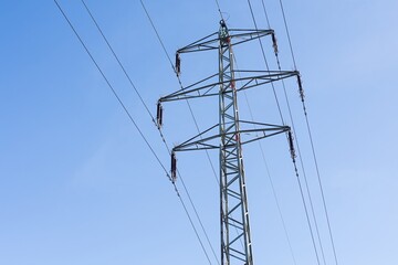 High voltage columns, in the background with blue sky and clouds. Prices of electricity, consumption, ecology.