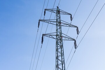 High voltage columns, in the background with blue sky and clouds. Prices of electricity, consumption, ecology.