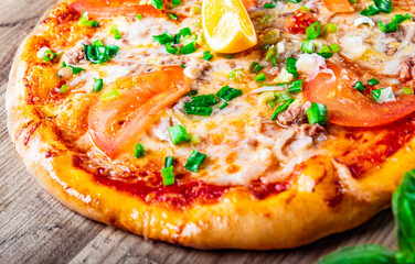 delicious pizza with tuna fish and lemon on wooden background