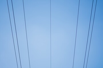 High voltage columns, in the background with blue sky and clouds. Prices of electricity, consumption, ecology.