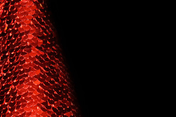abstract shiny red sequins on a black background defocus