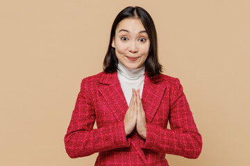 Pleaded woman of Asian ethnicity in red jacket hold hands folded in prayer gesture, begging about...